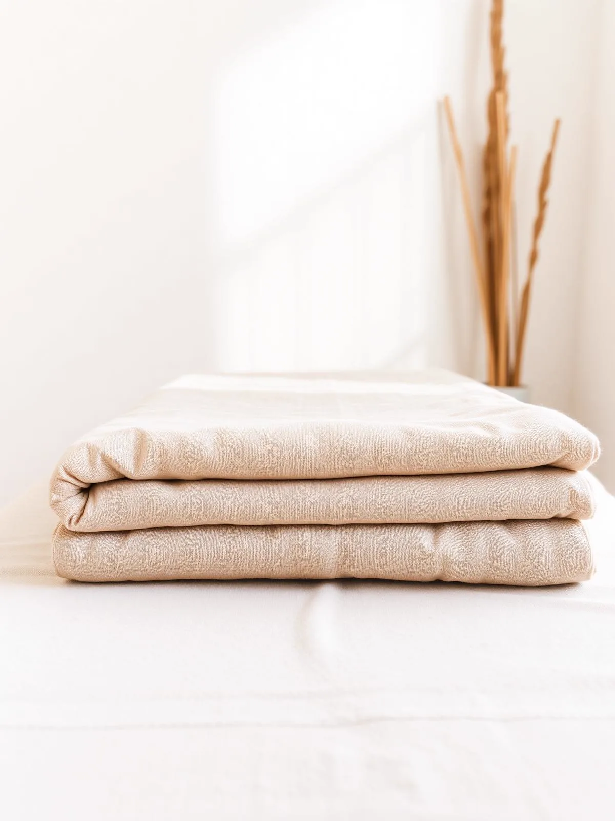 Head, Neck & Shoulders — stack of folded linen on a treatment couch in soft daylight